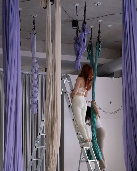 An instructor setting up a hammock on the studio's rig