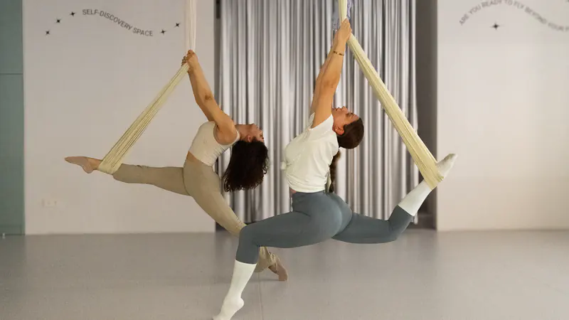 Two students in low-hung silks, close to the floor