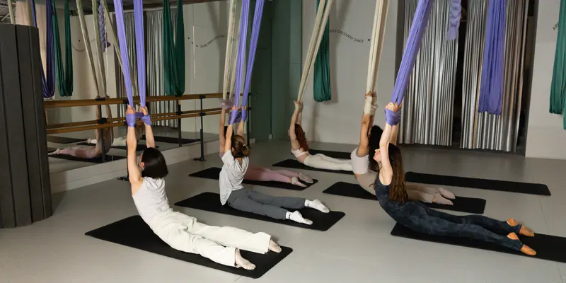 A class in progress, hammocks hung low over the mats
